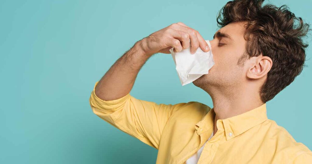 Un joven que tiene un ataque de alergia.