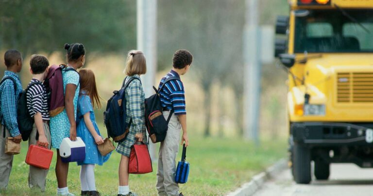 Estudiantes esperando el autobús escolar