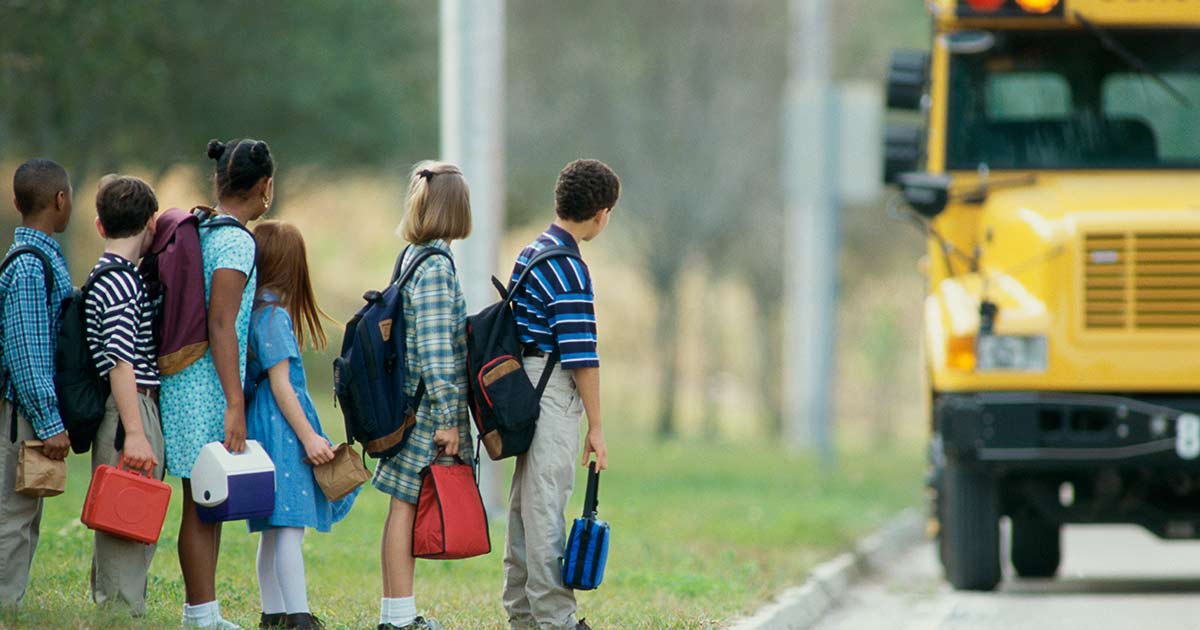 Estudiantes esperando el autobús escolar
